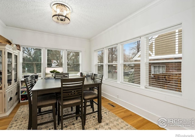 701 Mathews St, Fort Collins, CO 80524 - dining room featuring a textured ceiling, light wood-style flooring, ornamental molding, and a chandelier