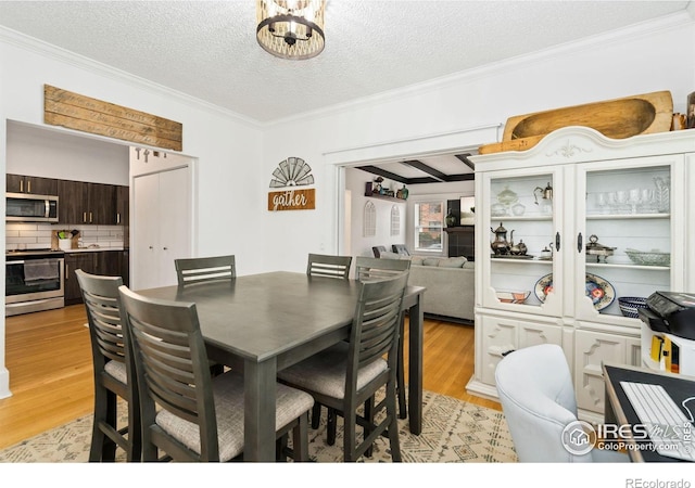 701 Mathews St, Fort Collins, CO 80524 - dining space with ornamental molding, light wood-style flooring, a textured ceiling, and a chandelier