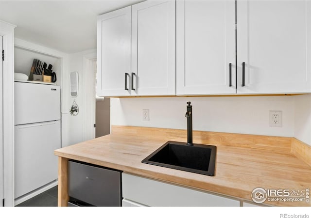 701 Mathews St, Fort Collins, CO 80524 - kitchen featuring freestanding refrigerator, white cabinetry, and a sink
