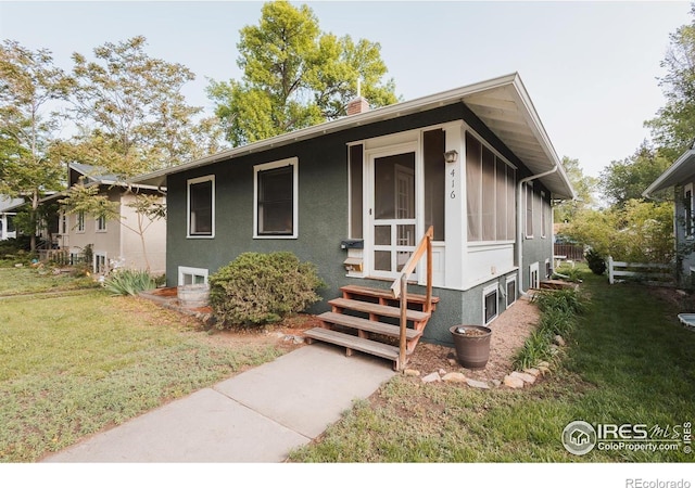 416 E Elizabeth St, Fort Collins, CO 80524 - view of front facade with entry steps, a front lawn, a chimney, and stucco siding