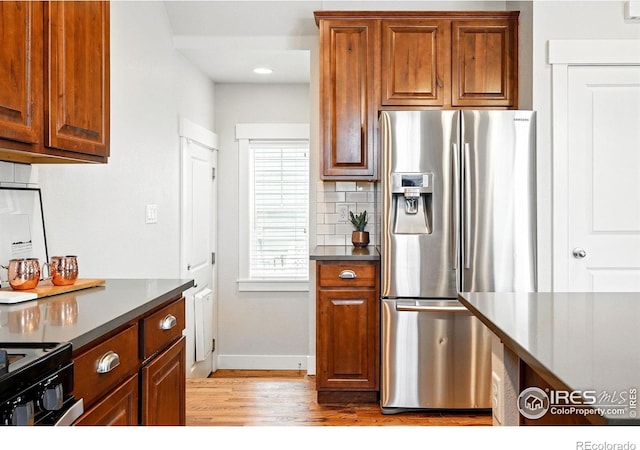 518 Hoyt Ln, Lafayette, CO 80026 - kitchen featuring stainless steel refrigerator with ice dispenser, light wood-type flooring, baseboards, backsplash, and brown cabinetry