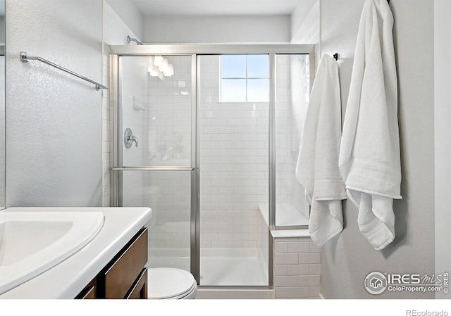518 Hoyt Ln, Lafayette, CO 80026 - bathroom with vanity, toilet, a stall shower, and a textured wall