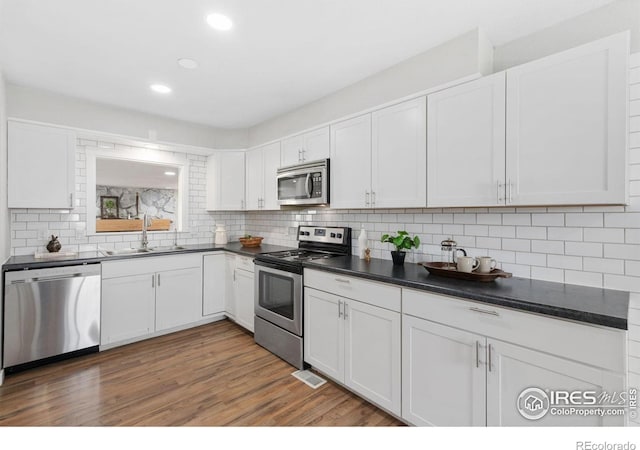 2836 W County Road 60e, Fort Collins, CO 80524 - kitchen featuring appliances with stainless steel finishes, a sink, dark countertops, white cabinetry, and recessed lighting