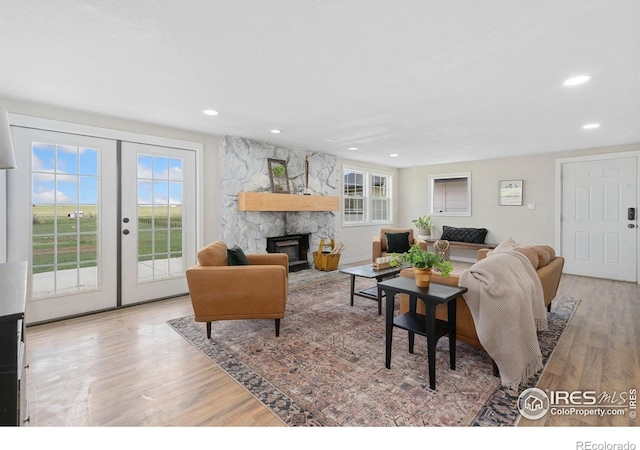 2836 W County Road 60e, Fort Collins, CO 80524 - living room featuring wood finished floors, a stone fireplace, recessed lighting, and french doors
