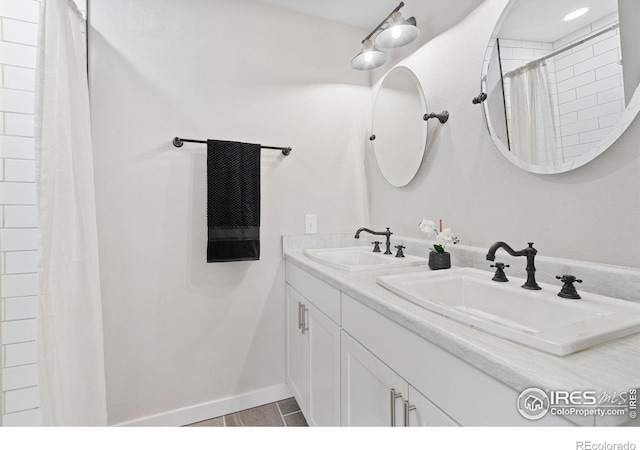 2836 W County Road 60e, Fort Collins, CO 80524 - bathroom featuring double vanity, tiled shower, and baseboards