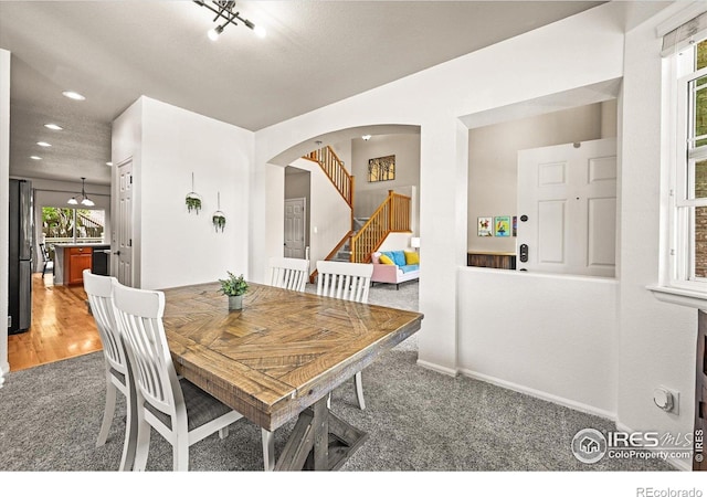 13445 Kearney St, Thornton, CO 80602 - dining area featuring light carpet, stairs, arched walkways, recessed lighting, and baseboards