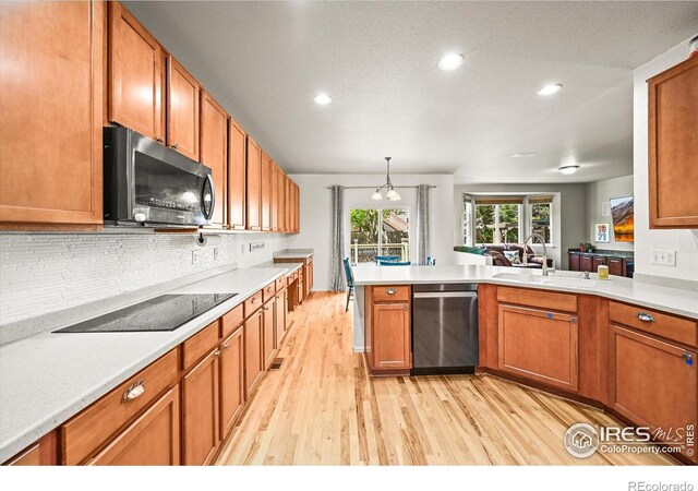 13445 Kearney St, Thornton, CO 80602 - kitchen with appliances with stainless steel finishes, light wood-style flooring, a sink, light countertops, and brown cabinetry