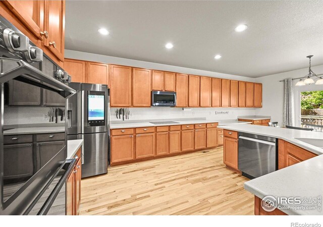 13445 Kearney St, Thornton, CO 80602 - kitchen featuring appliances with stainless steel finishes, light wood-style flooring, recessed lighting, light countertops, and pendant lighting