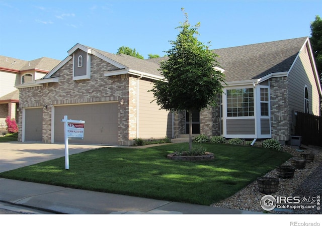 1536 Goshawk Dr, Longmont, CO 80504 - view of front of home featuring driveway, brick siding, a front yard, and an attached garage