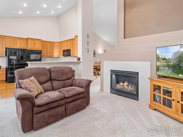 1536 Goshawk Dr, Longmont, CO 80504 - living area with high vaulted ceiling, light colored carpet, recessed lighting, and a tiled fireplace