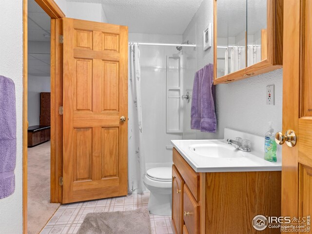 1536 Goshawk Dr, Longmont, CO 80504 - bathroom with vanity, a shower with curtain, toilet, a textured ceiling, and tile patterned flooring