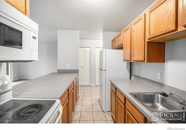 225 E 8th Ave Unit C-19, Longmont, CO 80504 - kitchen with white appliances, a sink, light tile patterned flooring, a textured ceiling, and light countertops