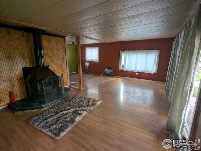 4809 Foothills Dr, Fort Collins, CO 80526 - unfurnished living room with wood finished floors, a wood stove, and wood walls