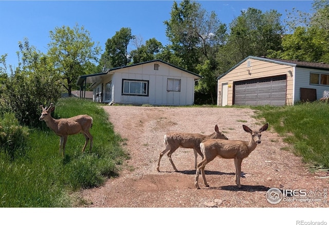 4809 Foothills Dr, Fort Collins, CO 80526 - view of front of house featuring a garage, board and batten siding, and an outbuilding