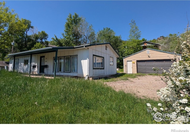 4809 Foothills Dr, Fort Collins, CO 80526 - view of front facade featuring a detached garage, board and batten siding, and an outbuilding