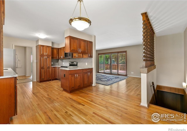 1409 Welch St, Fort Collins, CO 80524 - kitchen featuring light wood-type flooring, stainless steel appliances, light countertops, and brown cabinetry