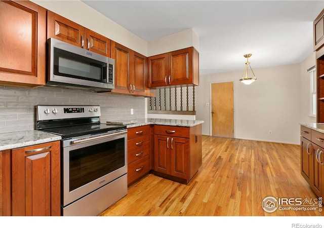 1409 Welch St, Fort Collins, CO 80524 - kitchen featuring stainless steel appliances, light wood finished floors, tasteful backsplash, and brown cabinetry