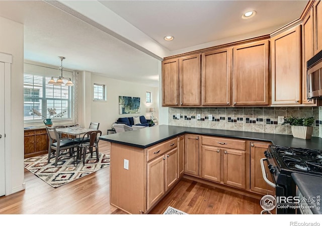 634 Homestead St, Lafayette, CO 80026 - kitchen with wood finished floors, dark countertops, a peninsula, tasteful backsplash, and recessed lighting