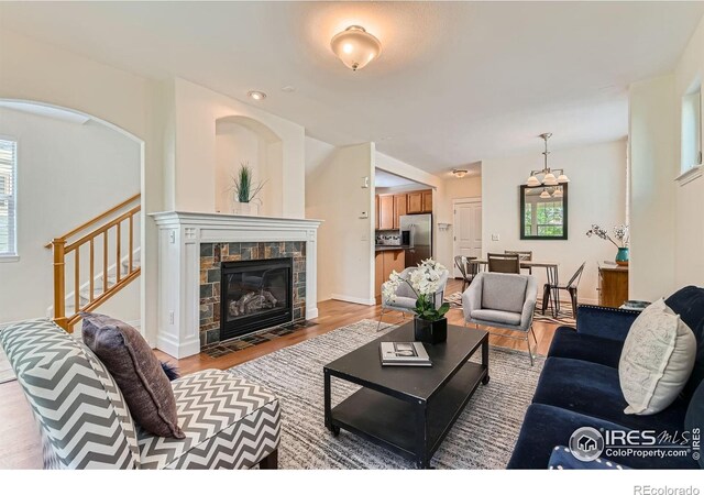 634 Homestead St, Lafayette, CO 80026 - living area featuring light wood-type flooring, stairs, a fireplace, and baseboards