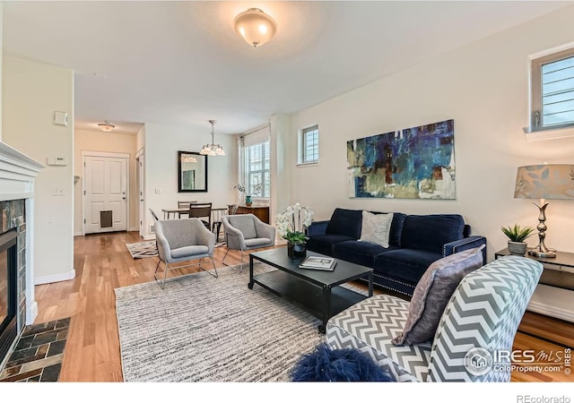 634 Homestead St, Lafayette, CO 80026 - living room with a tile fireplace, light wood-style floors, and a chandelier