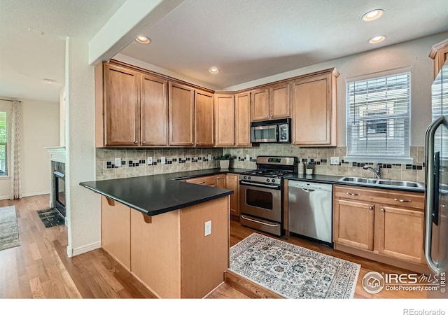634 Homestead St, Lafayette, CO 80026 - kitchen with appliances with stainless steel finishes, a sink, dark countertops, a peninsula, and backsplash