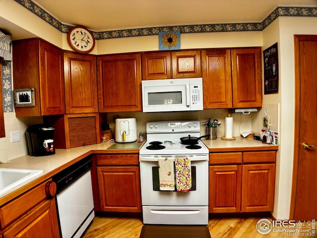 1515 Tulip Ct, Longmont, CO 80501 - kitchen featuring white appliances, decorative backsplash, light countertops, light wood-style floors, and a sink