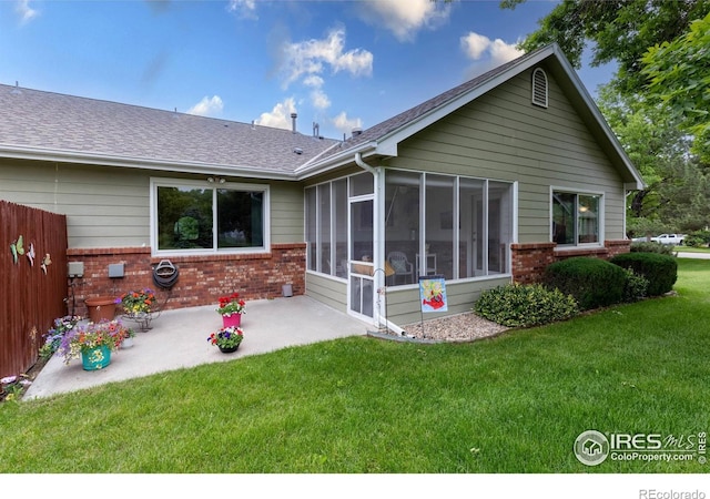 1515 Tulip Ct, Longmont, CO 80501 - rear view of property featuring brick siding, a sunroom, a patio area, and a lawn