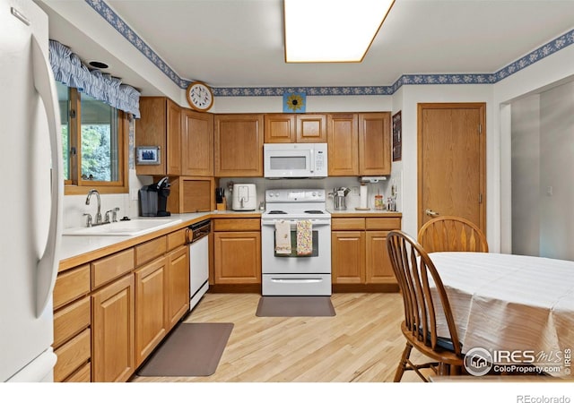 1515 Tulip Ct, Longmont, CO 80501 - kitchen featuring white appliances, light wood-style floors, light countertops, and a sink