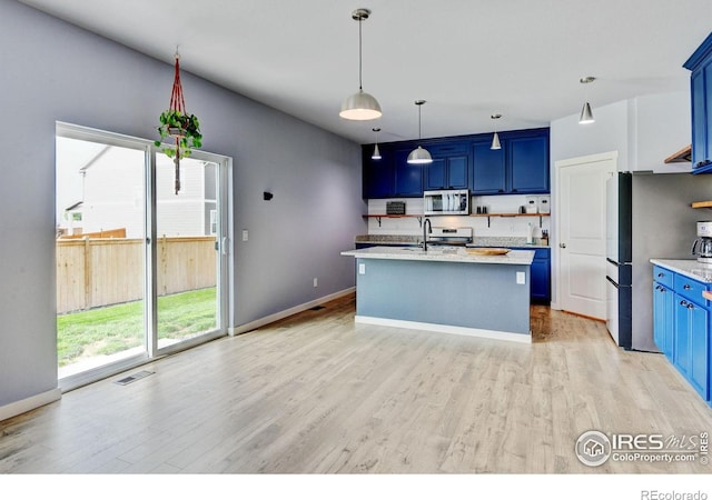 3657 Speedwell St, Wellington, CO 80549 - kitchen with stainless steel appliances, blue cabinetry, light wood-style floors, and decorative light fixtures