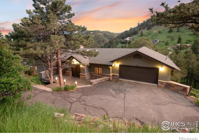 142 Meadowlook Way, Boulder, CO 80304 - view of front of property with a garage, stone siding, driveway, a mountain view, and a shingled roof