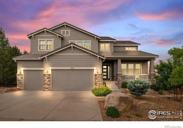 3075 Blue Mountain Dr, Broomfield, CO 80023 - craftsman-style house featuring covered porch, driveway, an attached garage, and stone siding