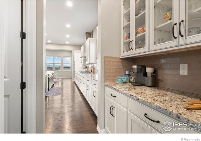 3075 Blue Mountain Dr, Broomfield, CO 80023 - kitchen featuring dark wood finished floors, glass insert cabinets, white cabinetry, decorative backsplash, and recessed lighting