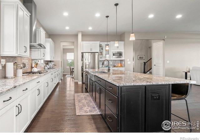 3075 Blue Mountain Dr, Broomfield, CO 80023 - kitchen featuring appliances with stainless steel finishes, wall chimney exhaust hood, white cabinets, a sink, and backsplash