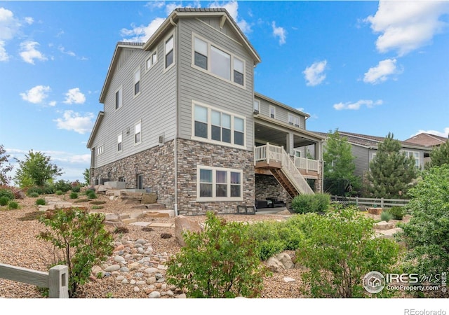 3075 Blue Mountain Dr, Broomfield, CO 80023 - rear view of property featuring stairway, stone siding, and a patio