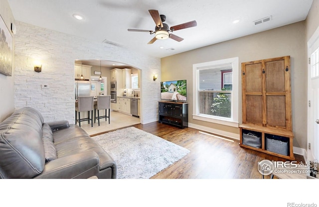 904 N Jefferson Ave, Loveland, CO 80537 - living room featuring arched walkways, a ceiling fan, light wood-style floors, healthy amount of natural light, and recessed lighting