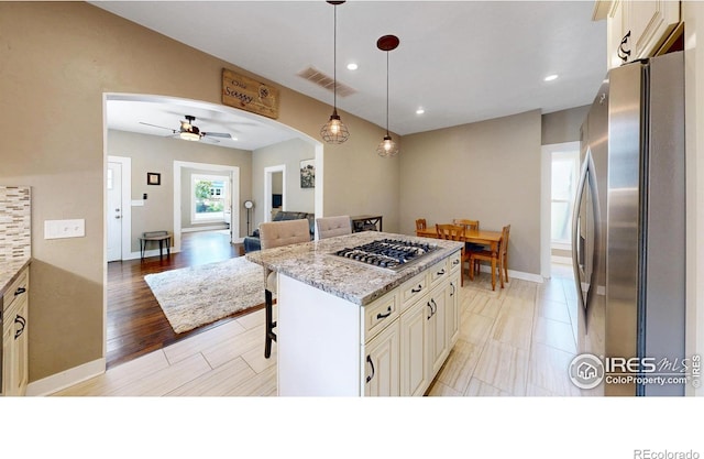 904 N Jefferson Ave, Loveland, CO 80537 - kitchen with appliances with stainless steel finishes, a ceiling fan, a kitchen island, arched walkways, and pendant lighting