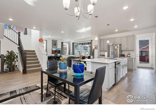 1958 Autumn Moon Dr, Windsor, CO 80550 - dining area featuring light wood-style flooring, recessed lighting, a chandelier, and stairs