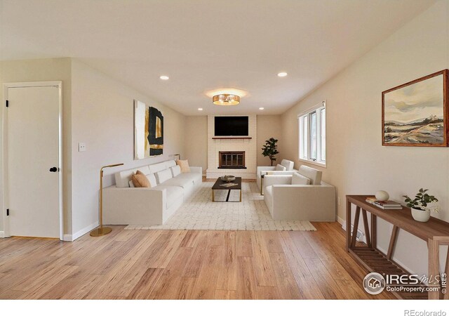 2217 14th St, Greeley, CO 80631 - living room featuring light wood-style flooring, a brick fireplace, baseboards, and recessed lighting
