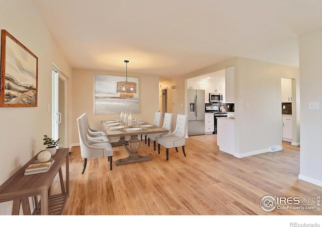 2217 14th St, Greeley, CO 80631 - dining space featuring light wood-type flooring, a chandelier, and baseboards