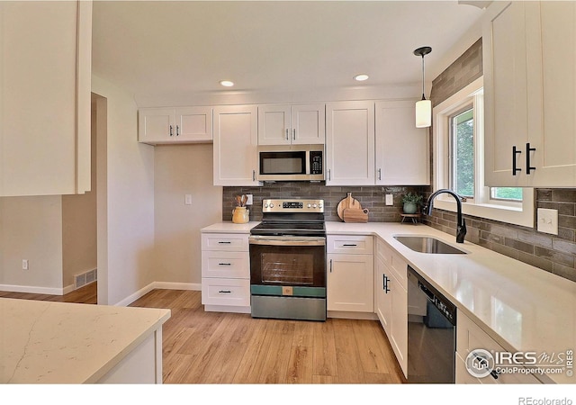 2217 14th St, Greeley, CO 80631 - kitchen with stainless steel appliances, a sink, light wood finished floors, white cabinetry, and recessed lighting