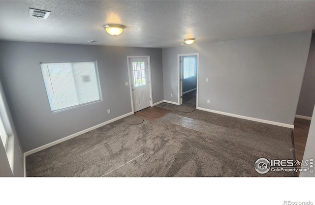 222 Platte St, Sterling, CO 80751 - empty room featuring a textured ceiling, carpet, and baseboards