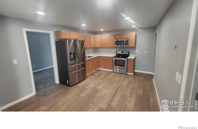 222 Platte St, Sterling, CO 80751 - kitchen with appliances with stainless steel finishes, light wood finished floors, baseboards, light countertops, and recessed lighting