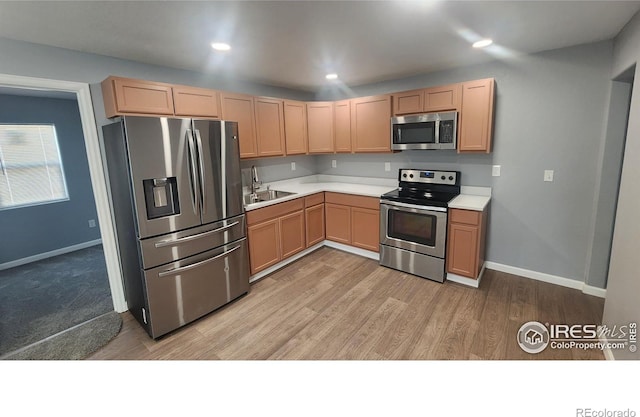222 Platte St, Sterling, CO 80751 - kitchen featuring appliances with stainless steel finishes, light countertops, light brown cabinets, and baseboards
