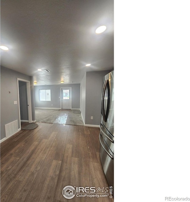 222 Platte St, Sterling, CO 80751 - unfurnished living room featuring dark wood-style floors, baseboards, recessed lighting, and a textured ceiling