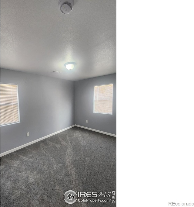 222 Platte St, Sterling, CO 80751 - empty room with dark colored carpet, baseboards, and a textured ceiling