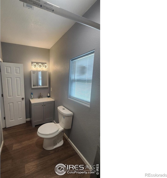 222 Platte St, Sterling, CO 80751 - bathroom with toilet, wood finished floors, vanity, and baseboards
