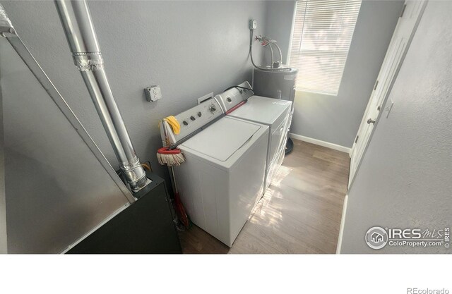 222 Platte St, Sterling, CO 80751 - washroom with independent washer and dryer, wood finished floors, baseboards, a textured wall, and water heater