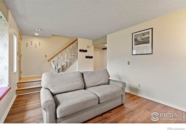 985 W 10th St Unit A5, Loveland, CO 80537 - living room featuring stairs, wood finished floors, a textured ceiling, and baseboards