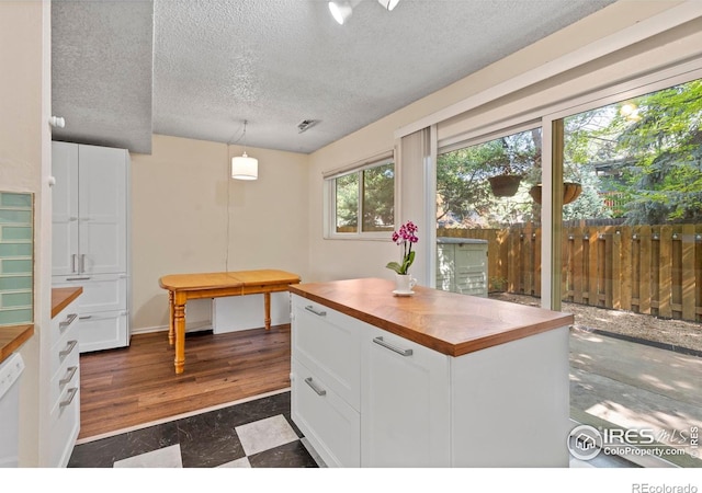 985 W 10th St Unit A5, Loveland, CO 80537 - kitchen featuring wood counters, white cabinets, a textured ceiling, decorative light fixtures, and dishwasher