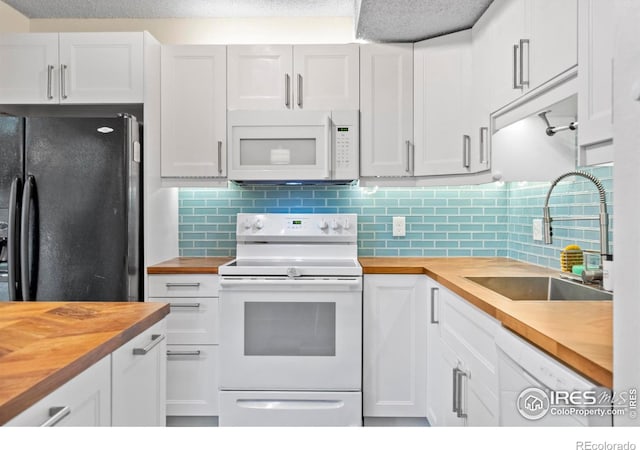 985 W 10th St Unit A5, Loveland, CO 80537 - kitchen with wood counters, white appliances, white cabinets, a sink, and backsplash
